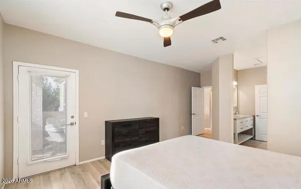 a large bedroom with bed and wooden floor