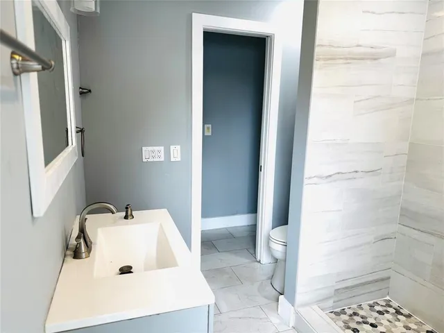 a kitchen with stainless steel appliances a stove top oven a sink a counter top space and cabinets