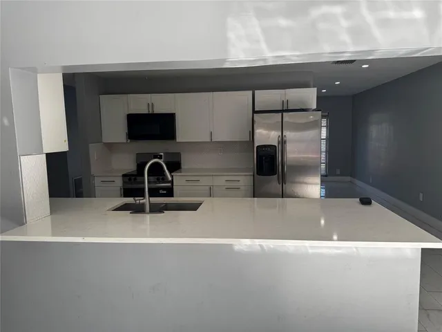 a kitchen with a sink and a refrigerator