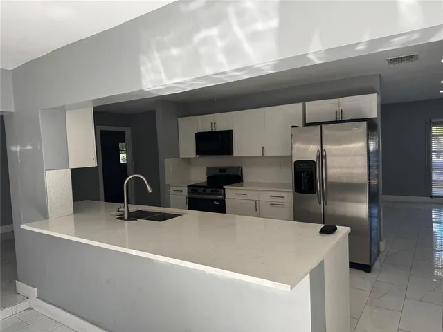 a kitchen with a refrigerator and a sink