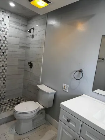 a bathroom with a toilet sink vanity and shower