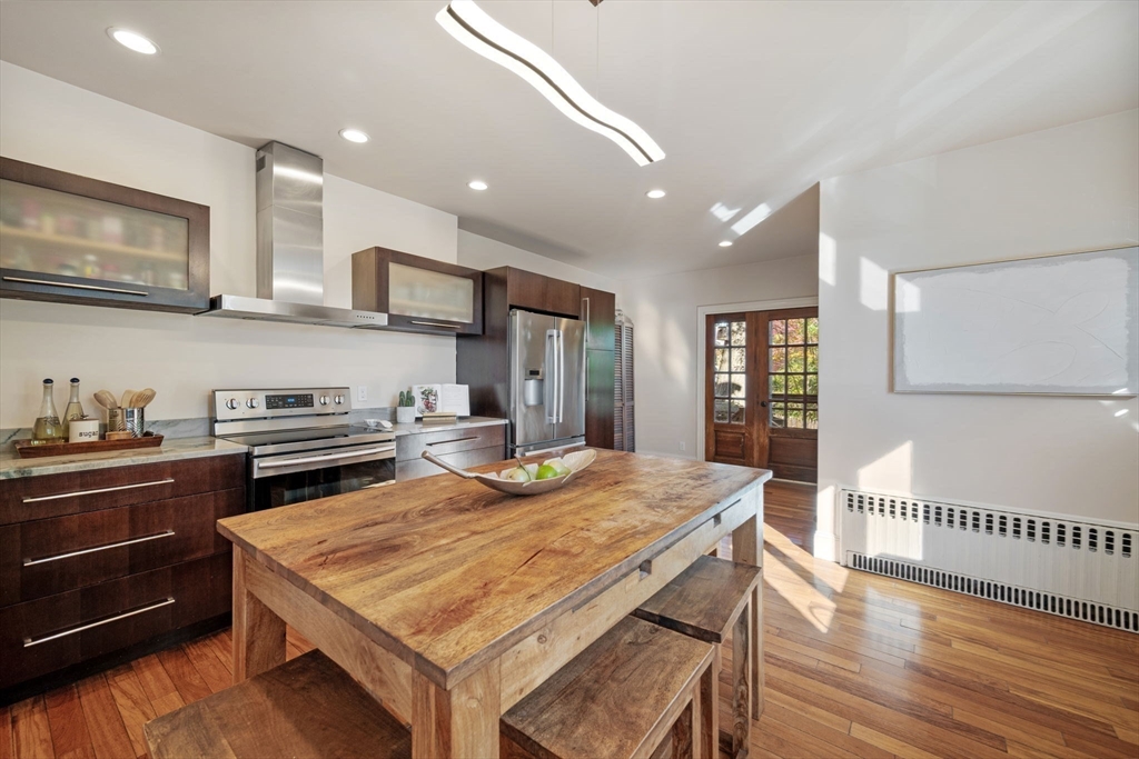 21 Bay View Drive Swampscott, MA 01907 - Photo 19 of 42 a kitchen with stainless steel appliances granite countertop a stove top oven a sink a dining table and chairs with wooden floor
