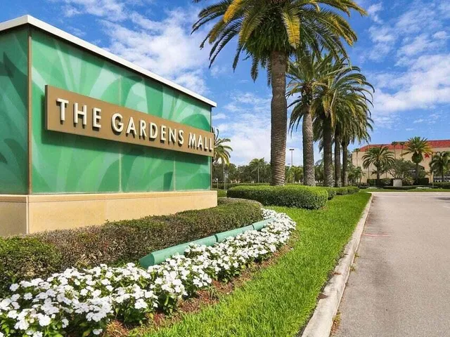 a front view of a house with a garden and lake view