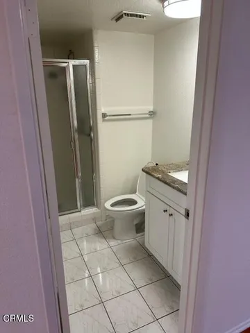 a bathroom with a granite countertop shower and a toilet