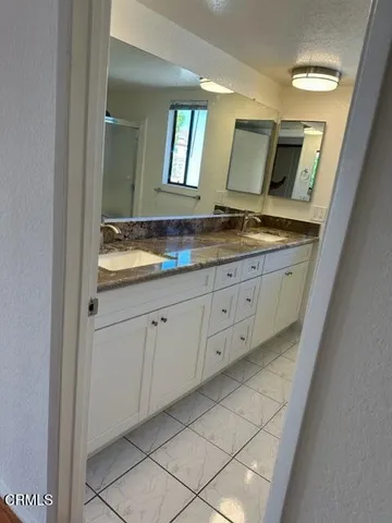a bathroom with a granite countertop sink and a mirror