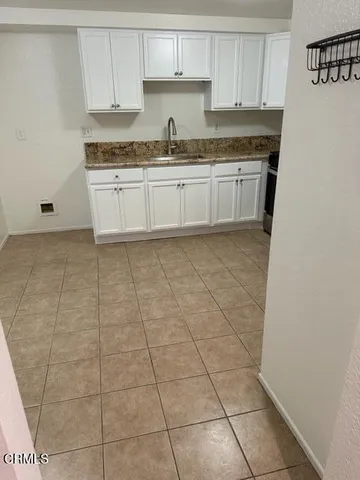a kitchen with granite countertop a sink a stove a microwave and cabinets