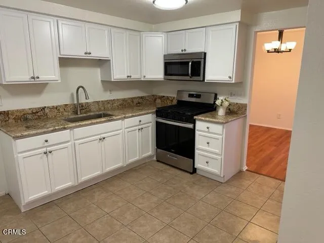 a kitchen with stainless steel appliances granite countertop a stove a sink and a microwave