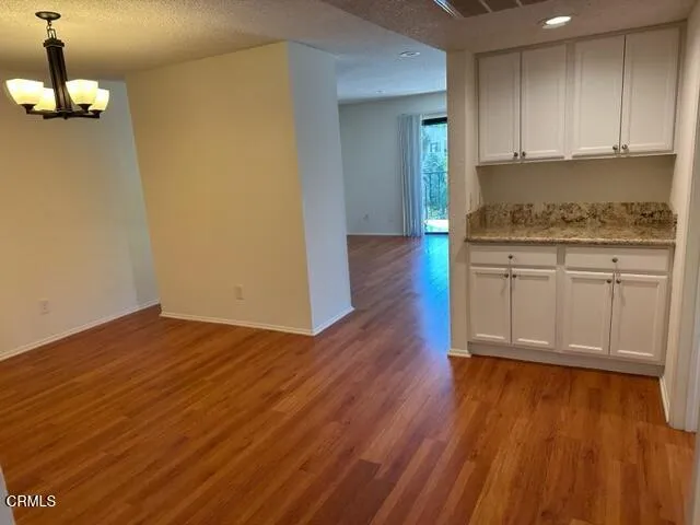 a view of a kitchen with wooden floor and cabinets