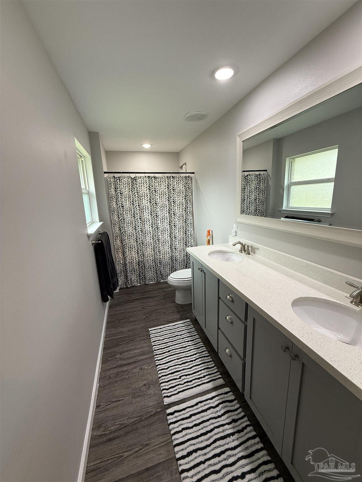 5553 Riviera Drive Milton, FL 32583 - Photo 16 of 23 a spacious bathroom with a double vanity sink and a mirror