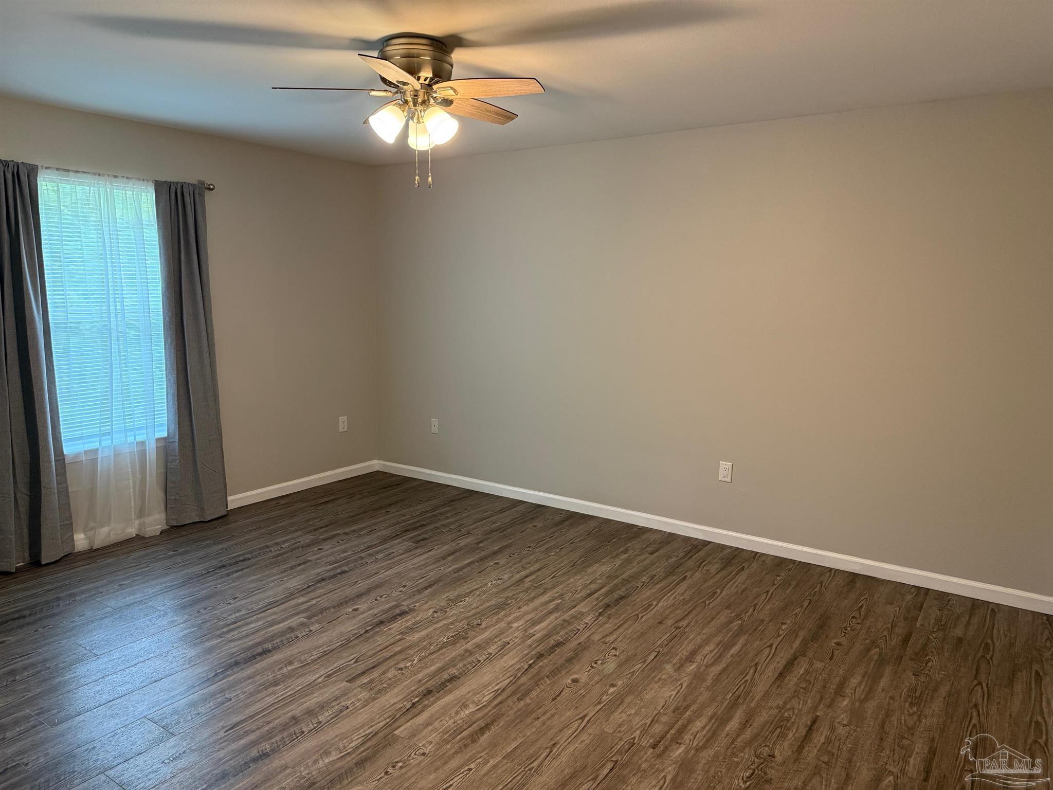 5553 Riviera Drive Milton, FL 32583 - Photo 10 of 23 wooden floor in an empty room with a window