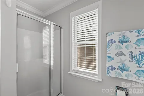 a view of a bedroom with a window and refrigerator