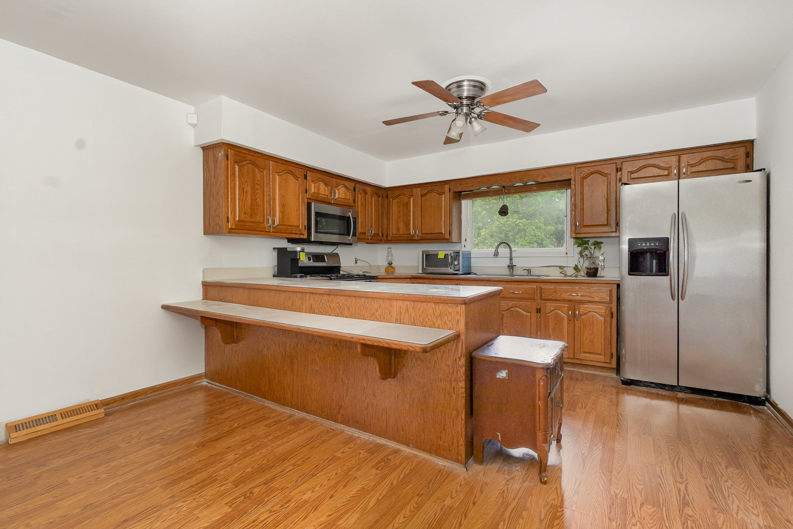 636 Patterson Road Joliet, IL 60436 - Photo 7 of 16 a kitchen with stainless steel appliances a dining table chairs refrigerator and sink