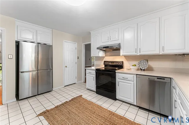 a kitchen with stainless steel appliances granite countertop a refrigerator sink and stove