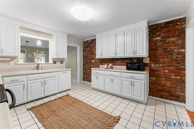 a kitchen with a sink window and cabinets