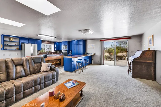 a kitchen with stainless steel appliances granite countertop a stove a refrigerator and a sink with wooden cabinets