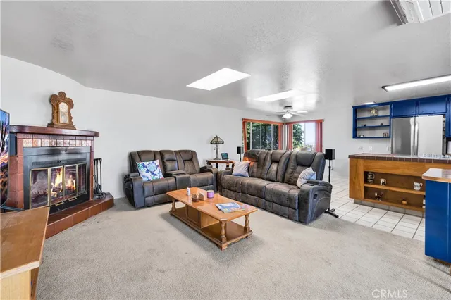 a living room with furniture kitchen view and a chandelier