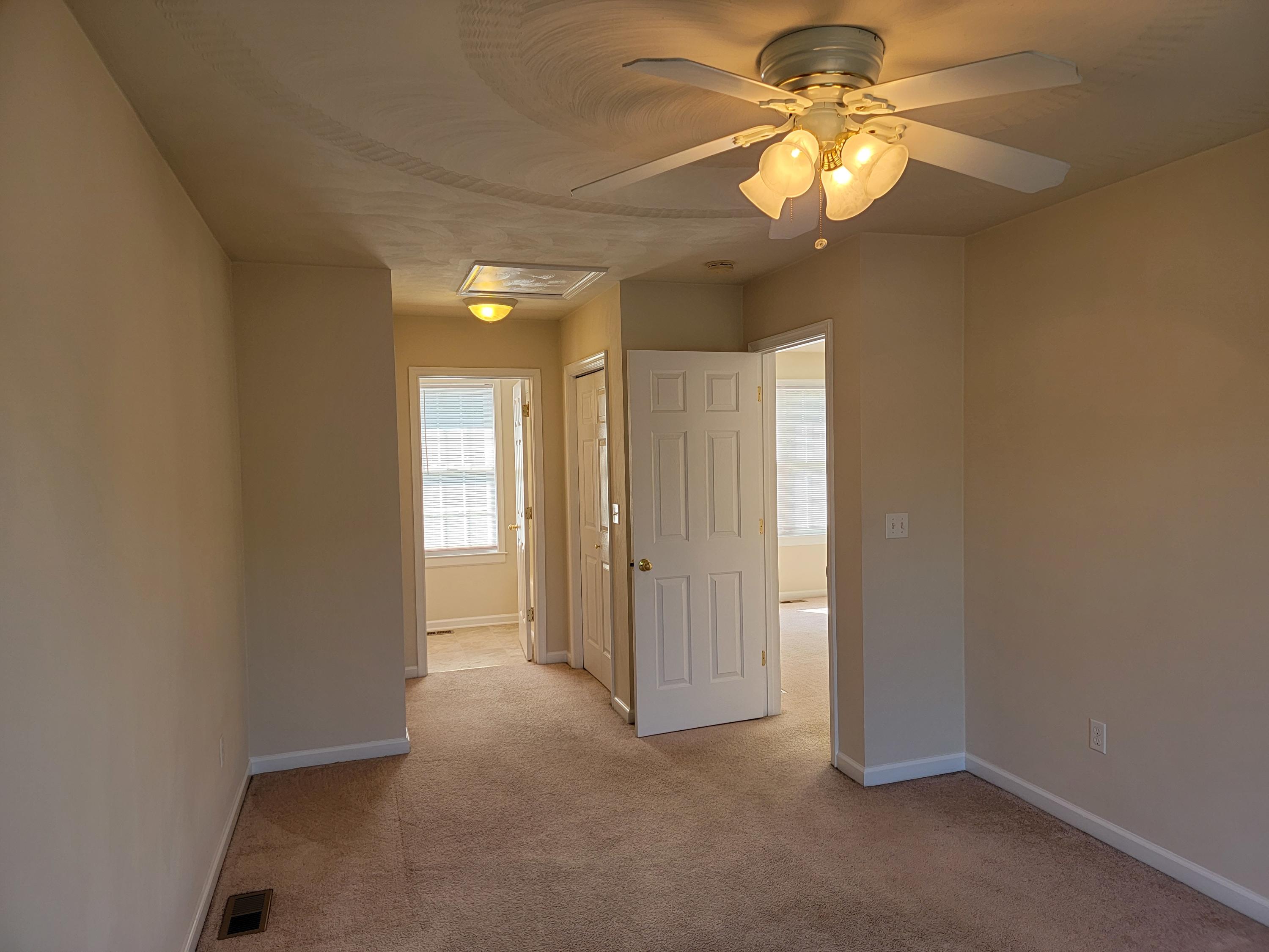 3305 Troxell Road Southeast Roanoke, VA 24014 - Photo 3 of 14 an empty room with a chandelier fan and windows