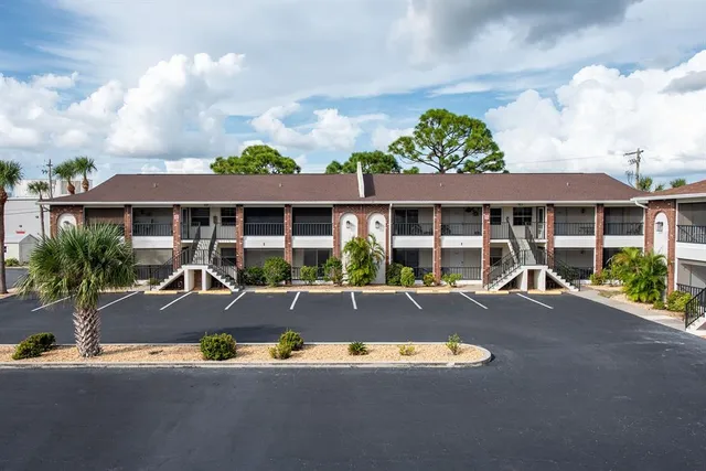a view of a white house with a swimming pool and sitting area