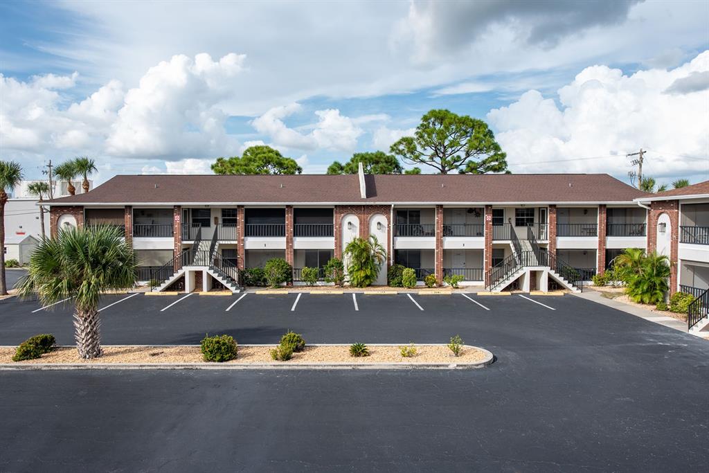 a view of a white house with a swimming pool and sitting area