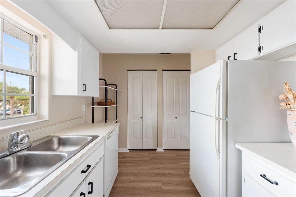 1531 Placida Road, Unit 1204 Englewood, FL 34223 - Photo 19 of 58 a kitchen with a sink a refrigerator and cabinets