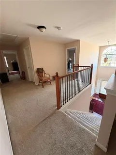 a view of a hall way with furniture and stairs