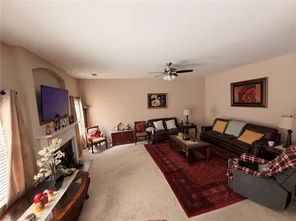 a living room with furniture a flat screen tv and gym equipment