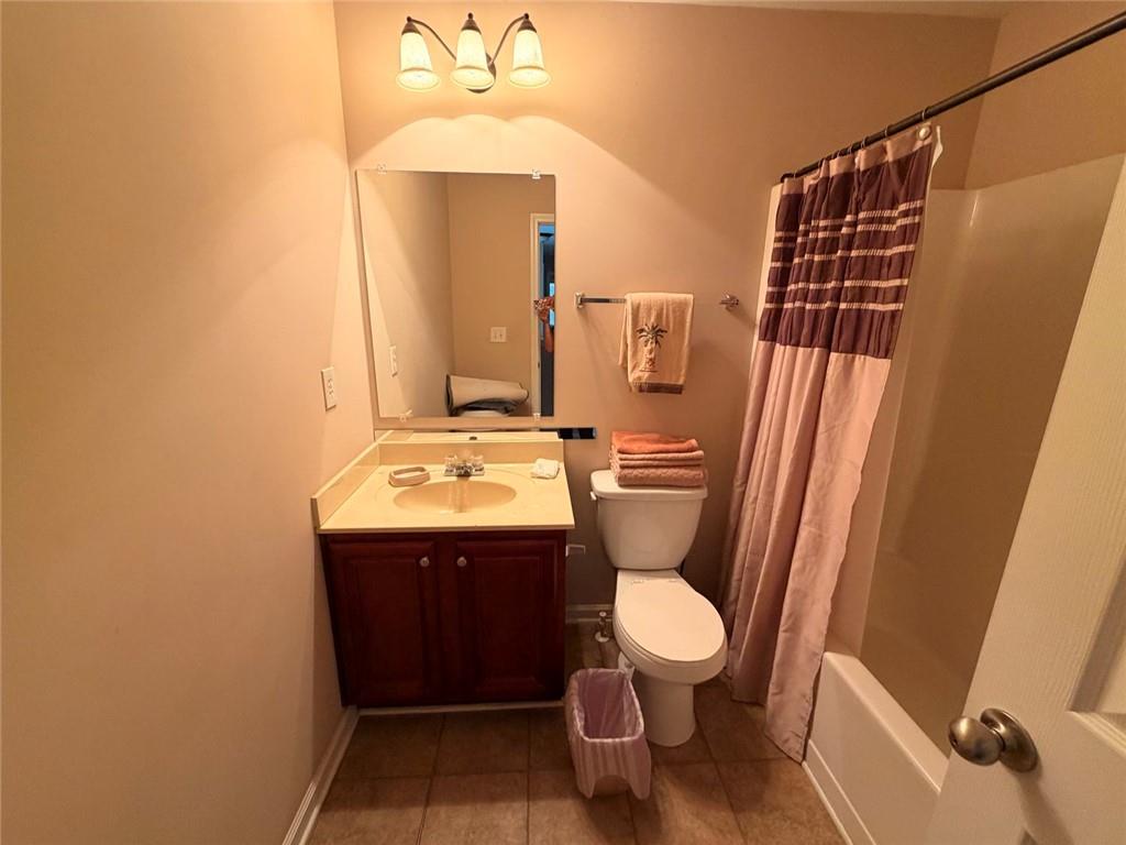 4080 Kittery Point Southwest Snellville, GA 30039 - Photo 9 of 25 a bathroom with a sink a toilet a mirror and shower