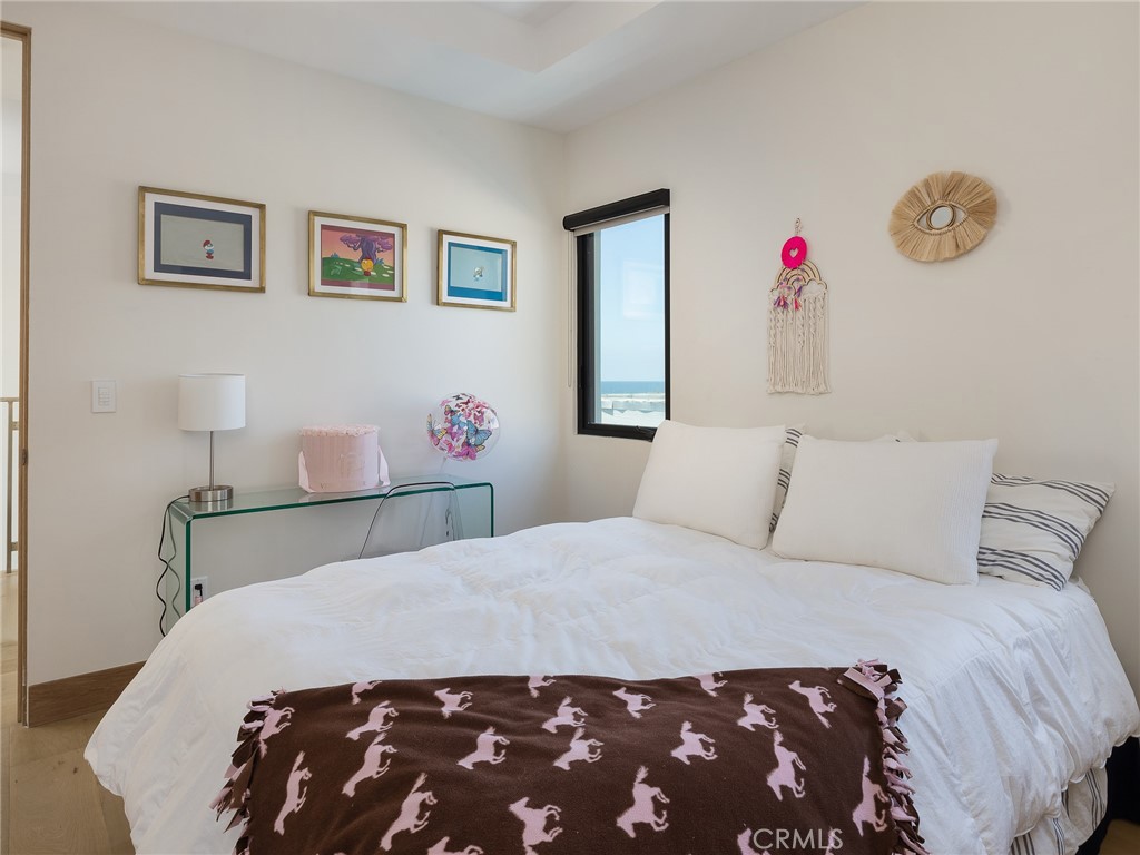 230 The Strand Hermosa Beach, CA 90254 - Photo 38 of 72 a bedroom with a bed and a chandelier