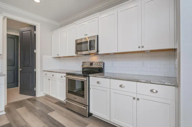 a kitchen with white cabinets and stainless steel appliances