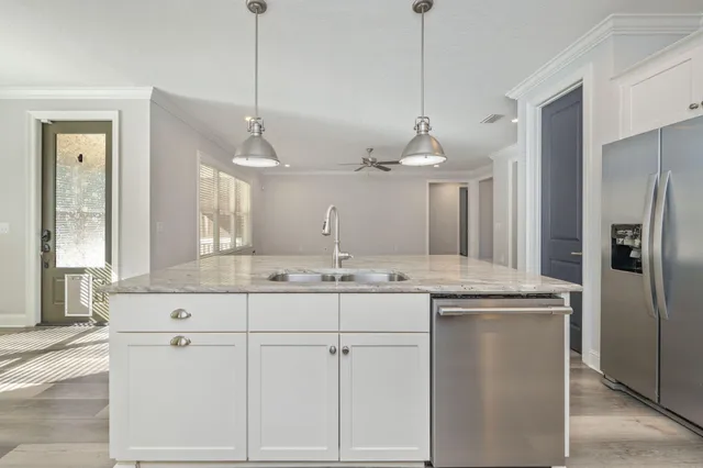 a kitchen with white cabinets and refrigerator
