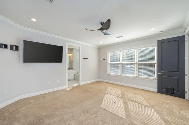 a view of an empty room with a window and a kitchen