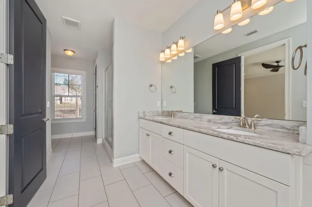a bathroom with a granite countertop sink a light fixture and a mirror
