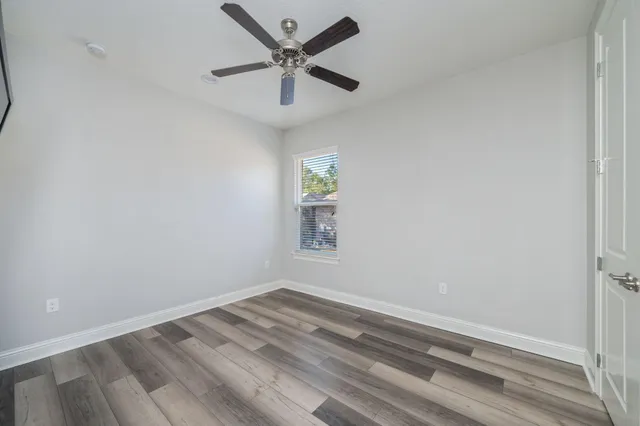 an empty room with a window and a ceiling fan