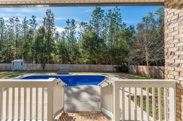 a view of a house with pool and chairs