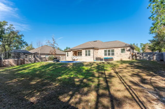 a front view of house with yard and trees in the background