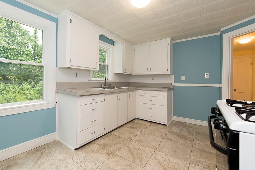 44 Charlotte Road Walpole, MA 02032 - Photo 3 of 25 a kitchen with a stove window and cabinets