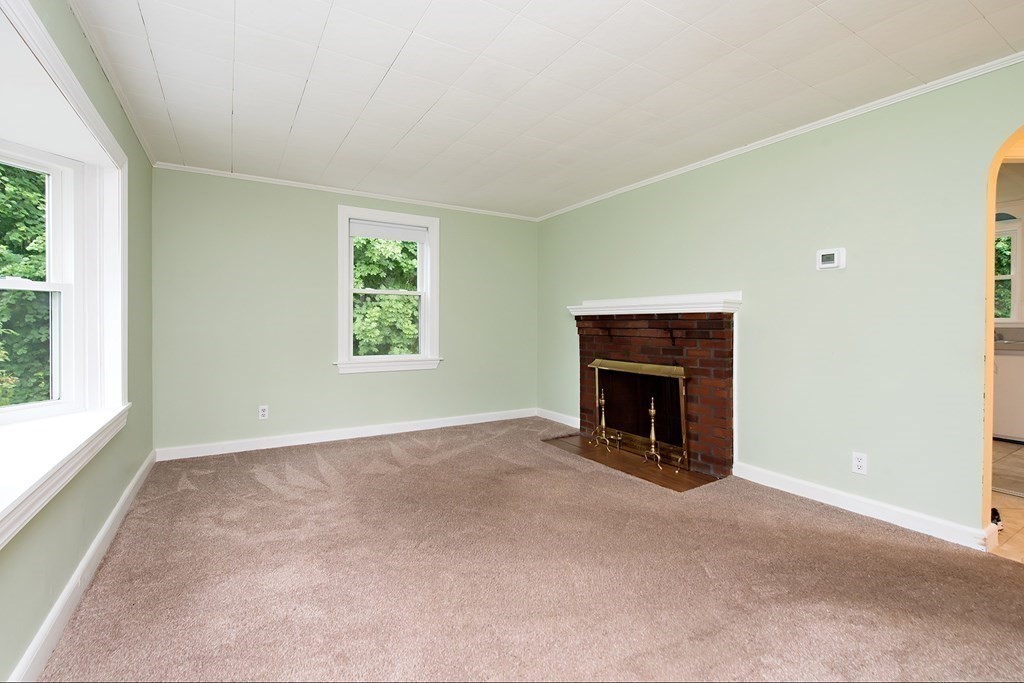 44 Charlotte Road Walpole, MA 02032 - Photo 6 of 25 an empty room with windows and fireplace