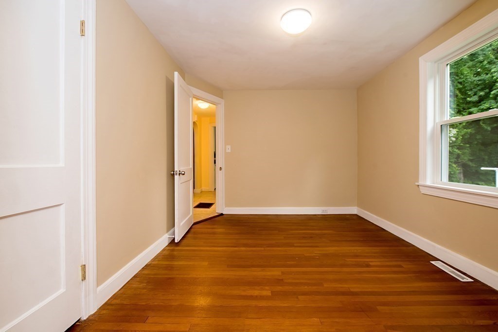 44 Charlotte Road Walpole, MA 02032 - Photo 8 of 25 a view of an empty room with wooden floor and a window