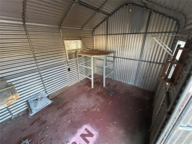 a view of a backyard with table and chairs and wooden fence