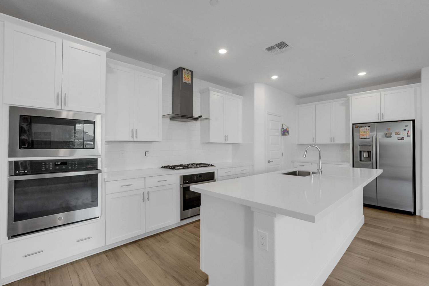 6705 Fathom Road Stockton, CA 95219 - Photo 6 of 19 a kitchen with stainless steel appliances a stove a sink a microwave and cabinets