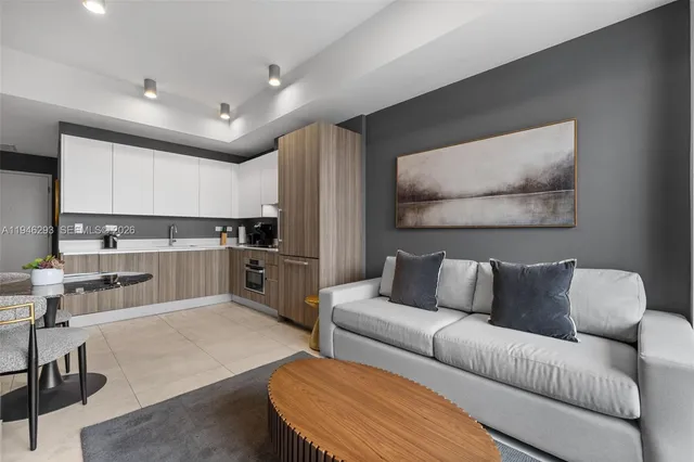 a living room with stainless steel appliances kitchen island granite countertop a couch and a view of kitchen