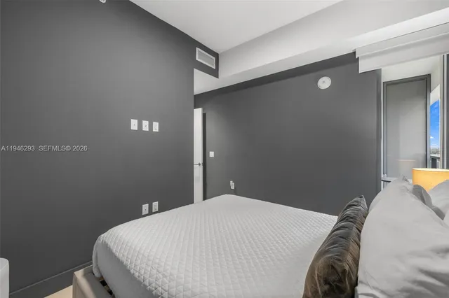 a bedroom with a bed and a lamp