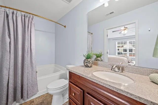 a bathroom with a granite countertop sink toilet and shower