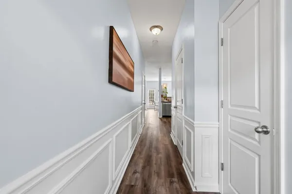 a view of a hallway with wooden floor and staircase