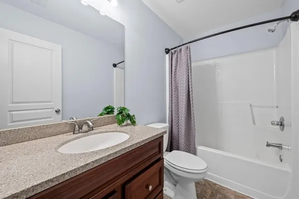 a bathroom with a granite countertop sink toilet a mirror and shower