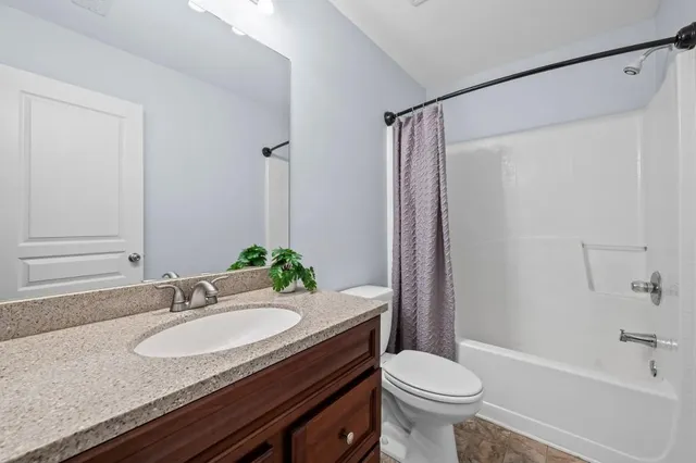a bathroom with a granite countertop sink toilet a mirror and shower