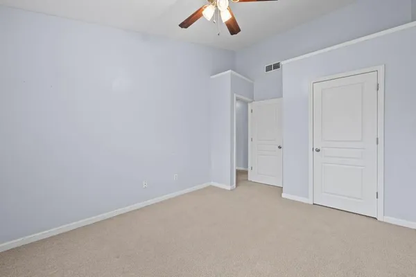 an empty room with a ceiling fan and window