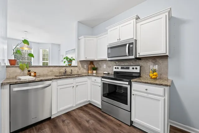 a kitchen with granite countertop white cabinets and white appliances