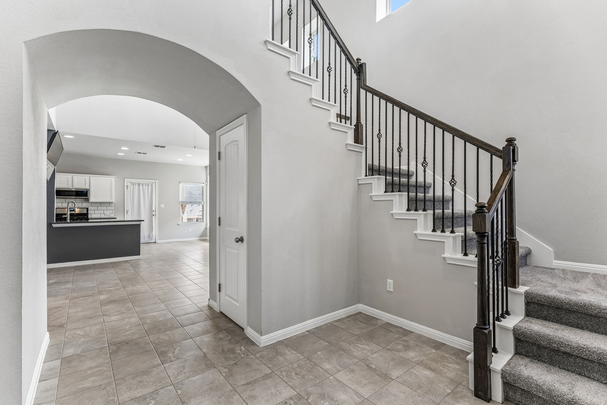 689 Nautical Loop Kyle, TX 78640 - Photo 7 of 34 A graceful staircase with intricate iron balusters ascends from the tiled entryway.