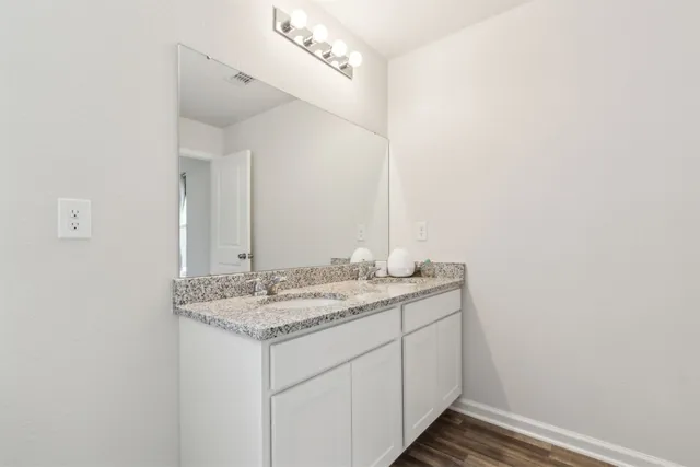 a bathroom with a granite countertop sink and a mirror